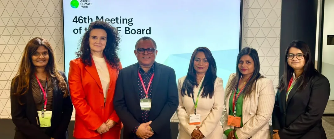 Six people stand in a row in front of a screen reading 46th Meeting of the GCF Board, with the Green Climate Fund logo.